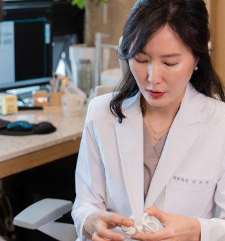 Dr. Bo-Young Kim explaining ear anatomy with a model